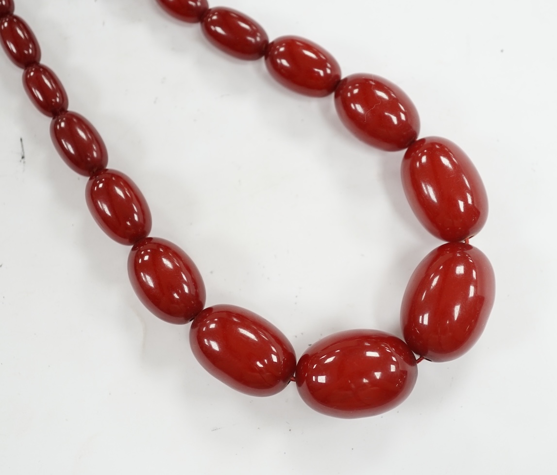 A single strand graduated simulated cherry amber bead necklace, 68cm, gross weight 52 grams. Condition - fair to good